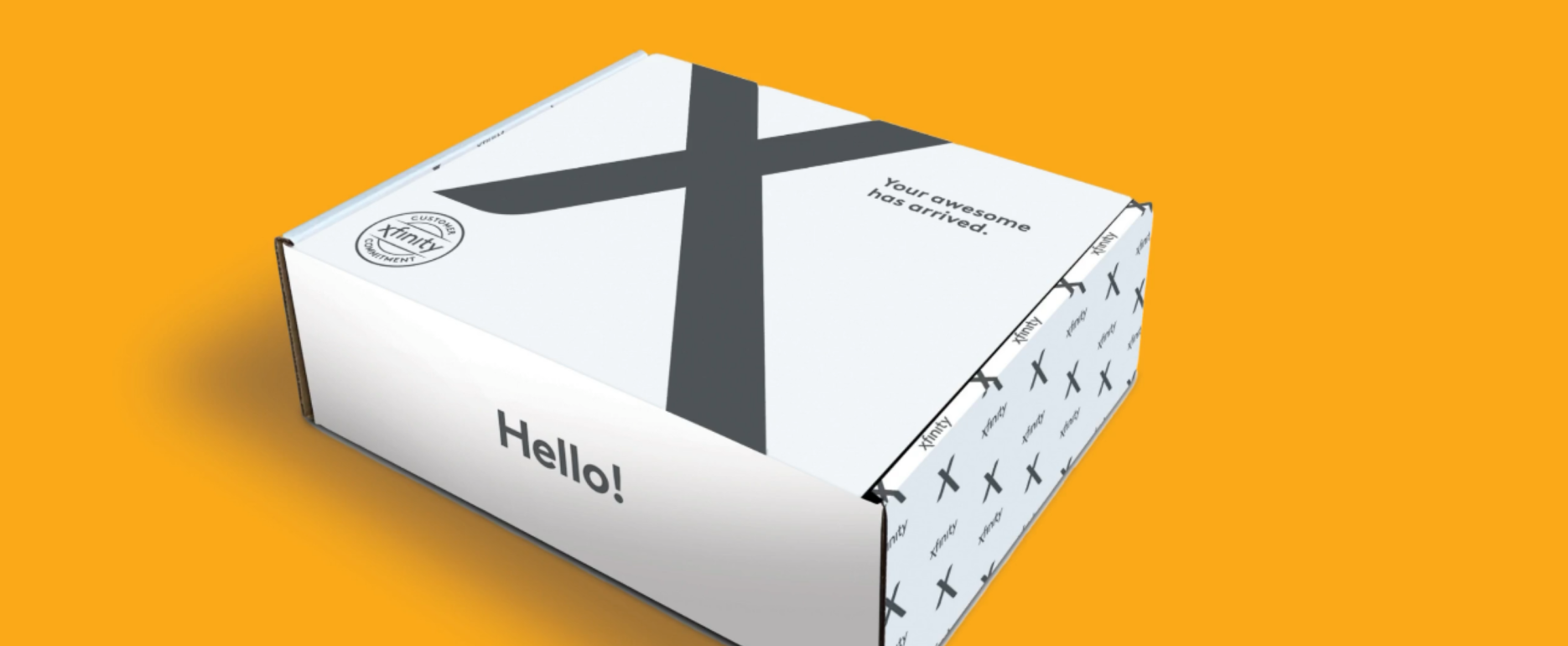 A white delivery box with a friendly "hello!" greeting, adorned with playful arrow patterns, sits against a warm orange background, evoking a sense of excitement for what's inside the Comcast subscription box.