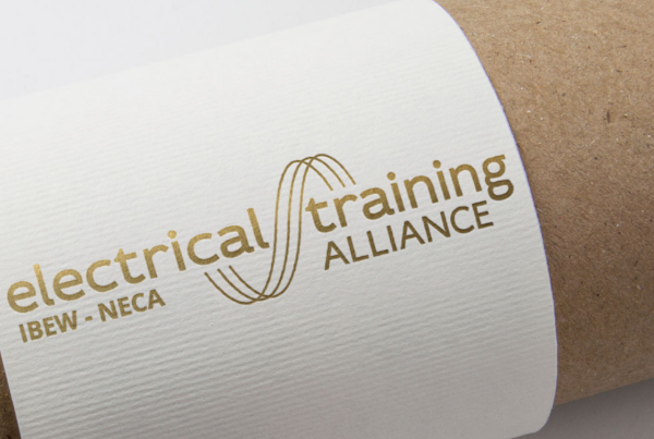 A roll of paper with the "electrical training alliance rebrand" logo imprinted on it.
