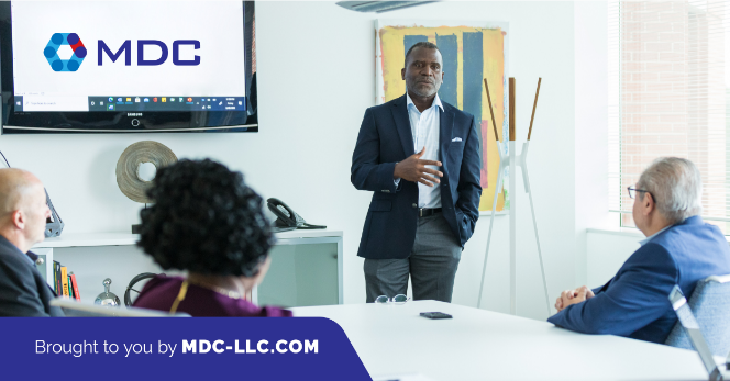 A professional presentation in progress at a modern office, sponsored by mdc-llc.com, focusing on Brand Development.