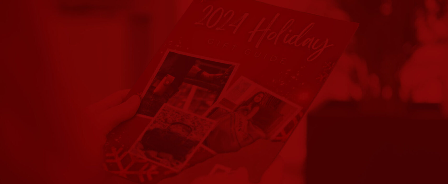 A person holds a brochure titled "2024 Holiday Gift Guide." The cover features several photos, including a close-up of a wrapped gift, a woman in festive clothing, and holiday decorations. The background is blurred, focusing attention on the brochure.