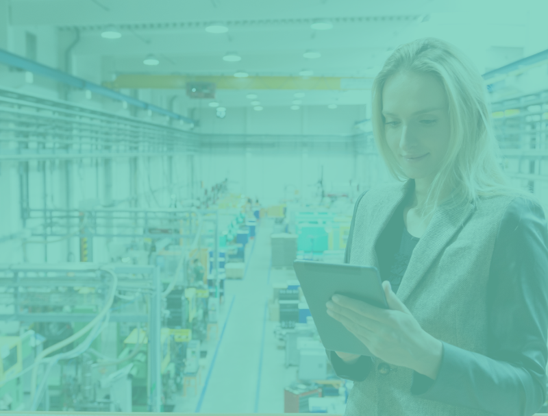 MOSAIC / Key Consumer Trends/ A woman in a business suit, representing key trends, is holding a tablet and smiling while standing in a large industrial facility with machinery and equipment in the background. The image has a teal overlay.