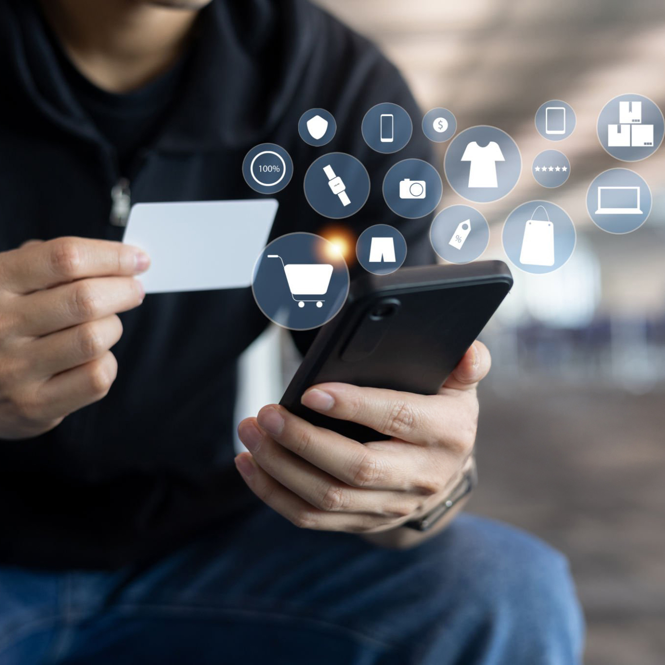 A person holds a credit card in one hand and a smartphone in the other, empowered by mPower to explore digital storefronts. Shopping icons, such as a cart and clothing, float around the phone, symbolizing online shopping. The background is blurred.