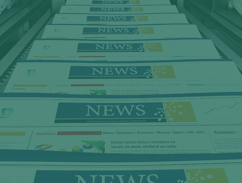 Stacks of freshly printed newspapers move along a conveyor belt in a printing facility, showcasing how Variable Data Printing can boost donor engagement and contributions, with "NEWS" clearly visible as the headline on each front page.